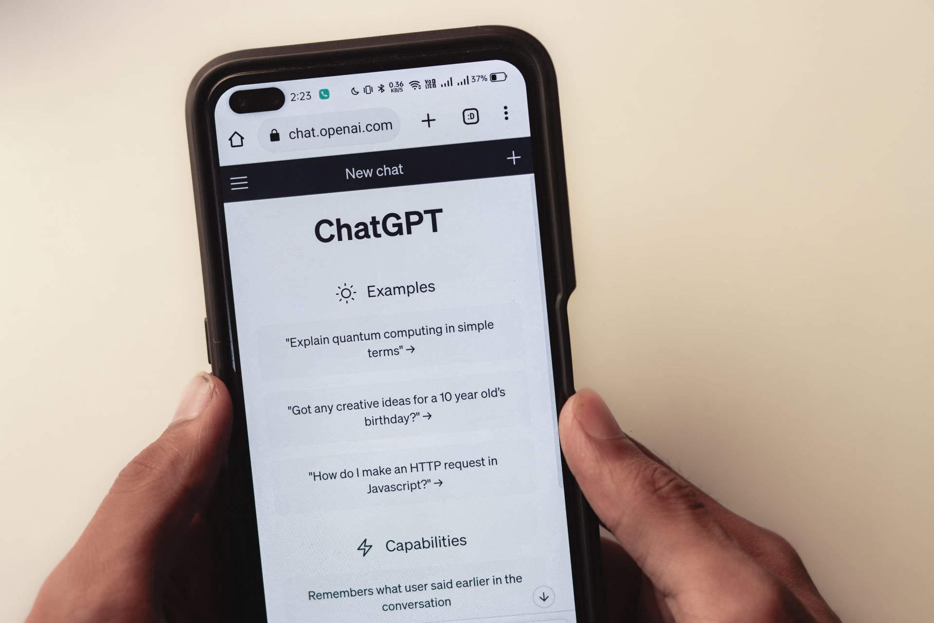 Hands holding a smartphone with ChatGPT open in the browser